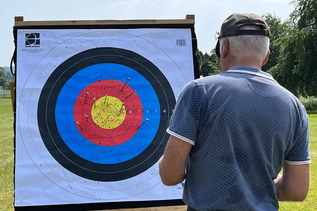 An archer checking arrows in an outdoor archery target