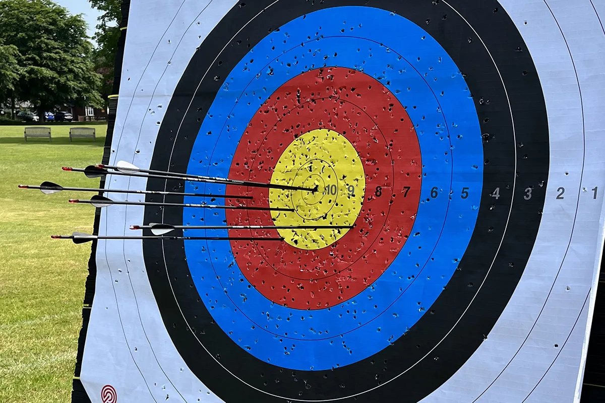 An outdoor archery target with arrows in the centre