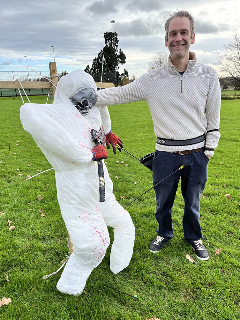 An archer with a scarecrow that has been struck by an arrow